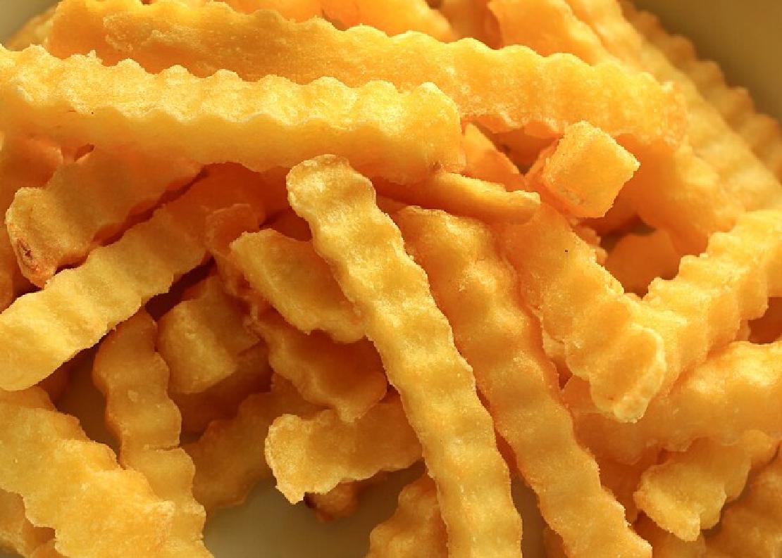 A close-up image of crinkle cut French fries.