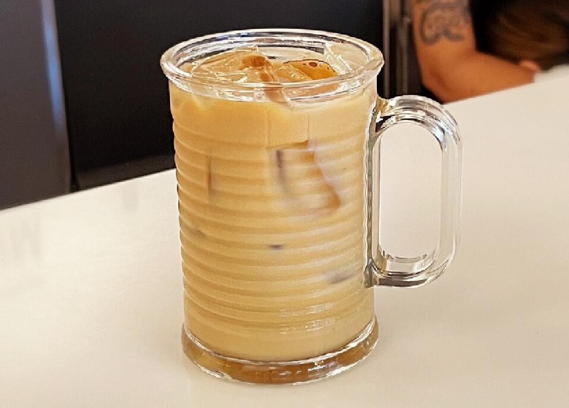A cup of iced coffee in a tall glass.