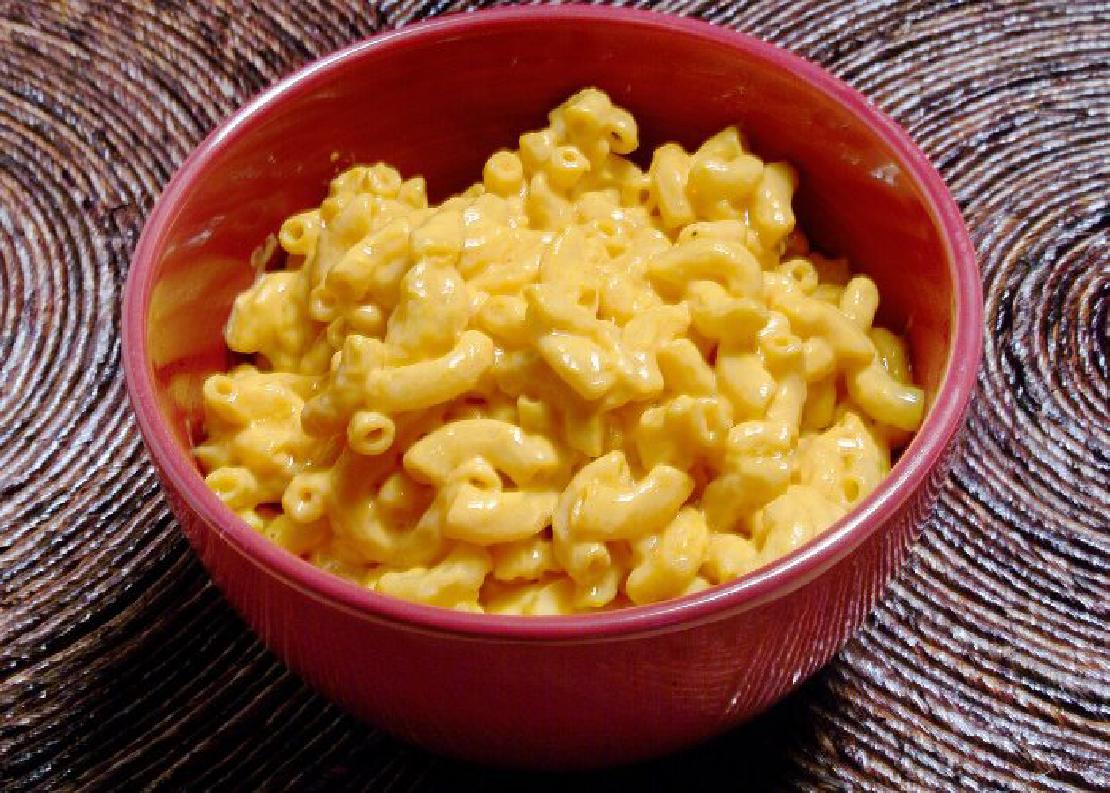 A red bowl filled with boxed-style mac and cheese