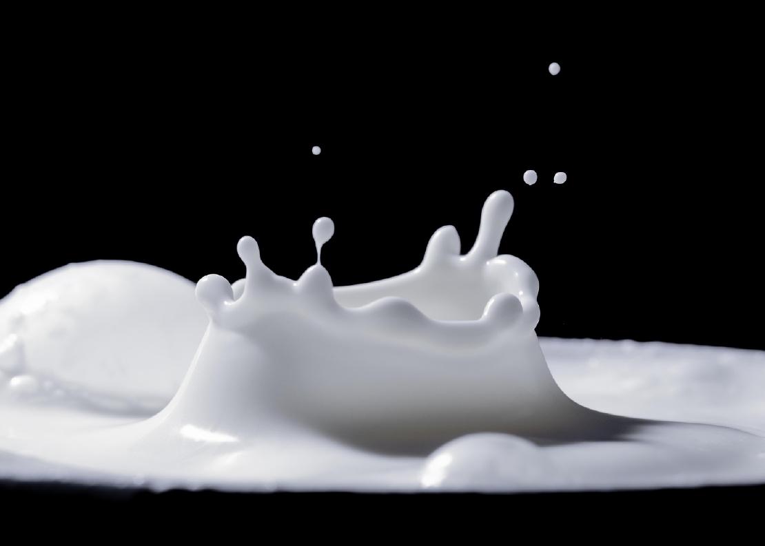 A close-up image of milk splashing into the air.